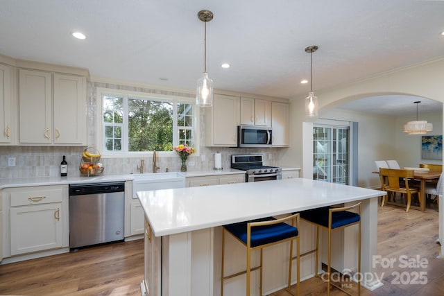 16132 Mclester Rd, Oakboro, NC 28129 - kitchen with stainless steel appliances, arched walkways, a sink, backsplash, and light wood finished floors