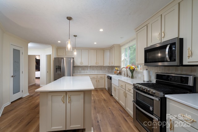 16132 Mclester Rd, Oakboro, NC 28129 - kitchen with stainless steel appliances, a kitchen island, decorative backsplash, light countertops, and recessed lighting