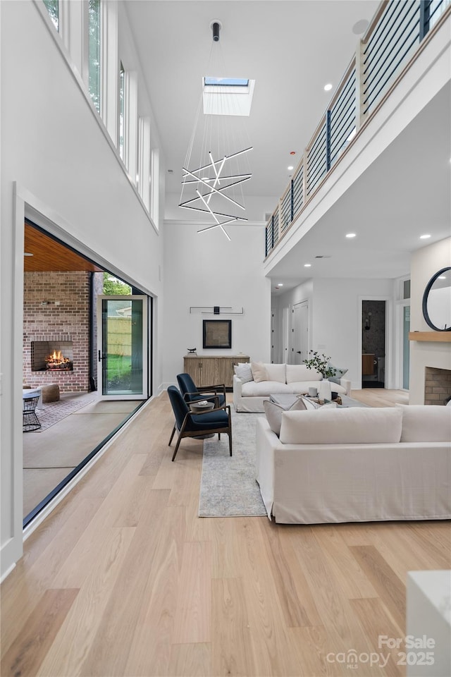 3822 Topsfield Rd, Charlotte, NC 28211 - living area featuring a fireplace, a high ceiling, a skylight, wood finished floors, and a chandelier