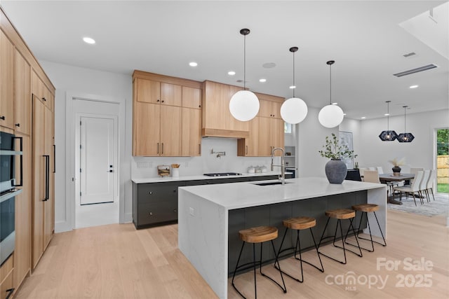 3822 Topsfield Rd, Charlotte, NC 28211 - kitchen with light wood-style flooring, light countertops, light brown cabinets, pendant lighting, and recessed lighting