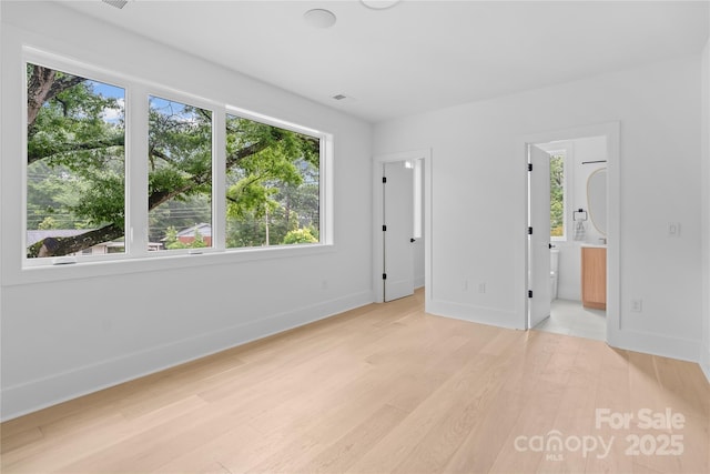 3822 Topsfield Rd, Charlotte, NC 28211 - unfurnished bedroom with multiple windows, light wood-type flooring, and connected bathroom