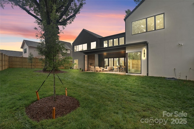 3822 Topsfield Rd, Charlotte, NC 28211 - back of property at dusk featuring a fenced backyard, a patio area, outdoor lounge area, and stucco siding