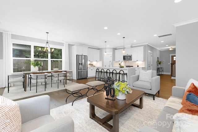 2517 Marlowe Ave, Charlotte, NC 28208 - living area featuring light wood finished floors, recessed lighting, and ornamental molding