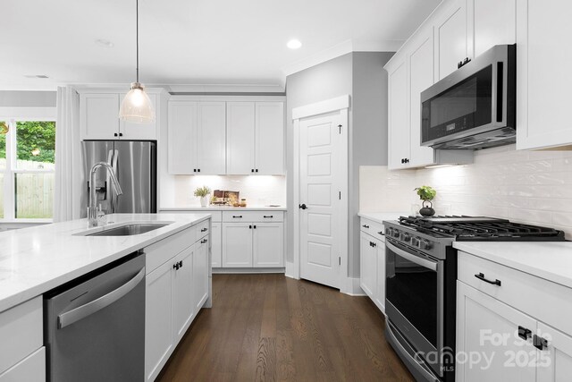 2517 Marlowe Ave, Charlotte, NC 28208 - kitchen with stainless steel appliances, dark wood-style floors, white cabinetry, backsplash, and decorative light fixtures