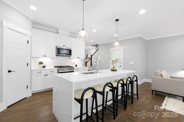 2517 Marlowe Ave, Charlotte, NC 28208 - kitchen featuring stainless steel appliances, ornamental molding, decorative backsplash, dark wood finished floors, and a kitchen island with sink