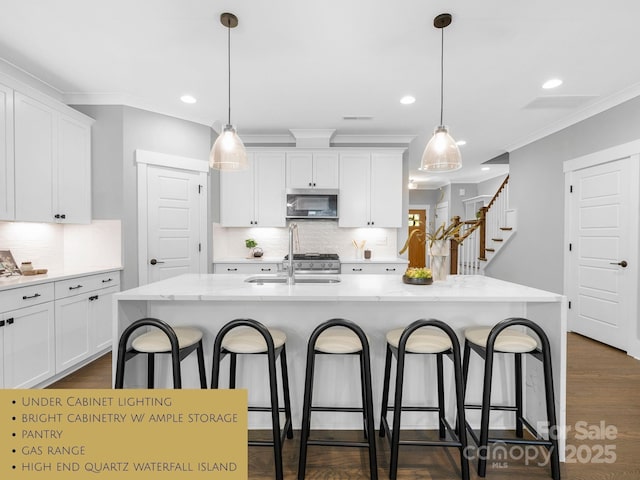 2517 Marlowe Ave, Charlotte, NC 28208 - kitchen with stainless steel microwave, a breakfast bar area, white cabinetry, recessed lighting, and crown molding