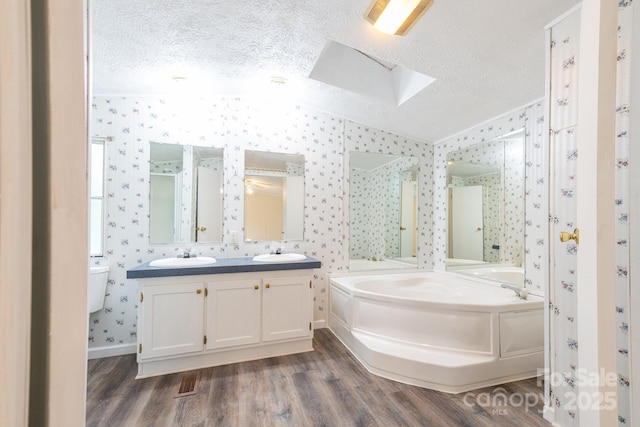 1884 Kensway Dr, Hudson, NC 28638 - bathroom featuring wallpapered walls, vaulted ceiling, a textured ceiling, a skylight, and a bath