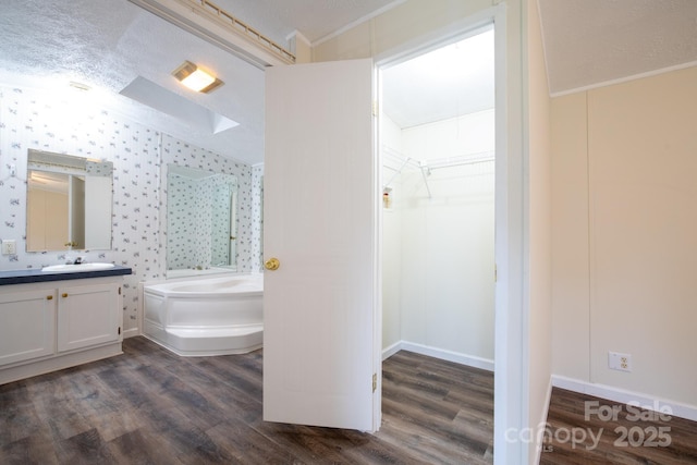 1884 Kensway Dr, Hudson, NC 28638 - bathroom with a bath, vanity, wood finished floors, a walk in closet, and ornamental molding