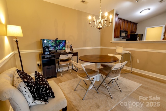 11867 Ridgeway Park Dr, Charlotte, NC 28277 - dining room with a chandelier, light wood-style flooring, and vaulted ceiling