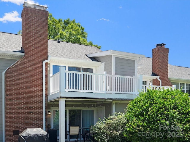 9404 S Vicksburg Park Ct, Charlotte, NC 28210 - rear view of property featuring roof with shingles, a chimney, brick siding, and a wooden deck