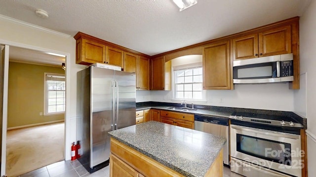 2507 Birnen Dr, Charlotte, NC 28210 - kitchen featuring appliances with stainless steel finishes, a sink, brown cabinets, a center island, and light tile patterned flooring