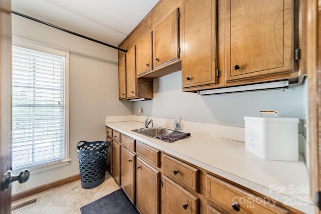 8698 Rocky River Rd, Harrisburg, NC 28075 - kitchen featuring a sink, brown cabinetry, healthy amount of natural light, and light countertops