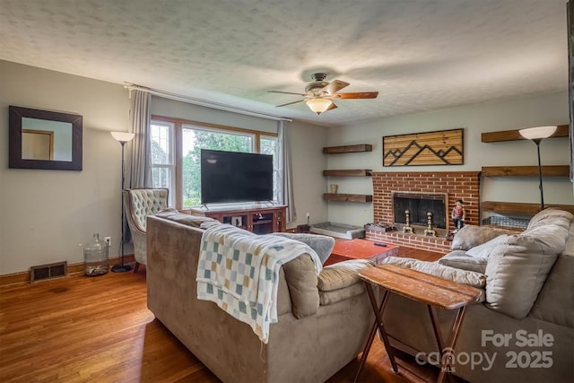 826 Jamestown Rd, Morganton, NC 28655 - living room featuring ceiling fan, wood finished floors, baseboards, a brick fireplace, and a textured ceiling