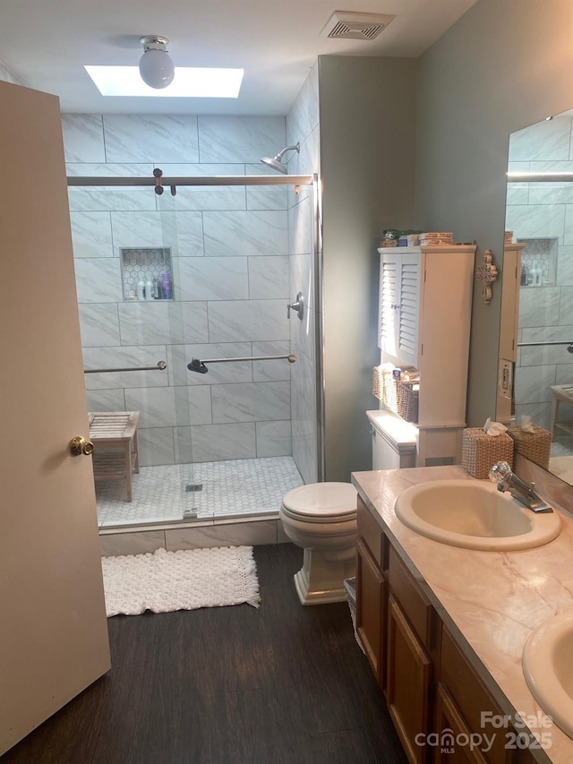 9612 Farmridge Ln, Matthews, NC 28105 - bathroom with wood finished floors, a skylight, a stall shower, and double vanity