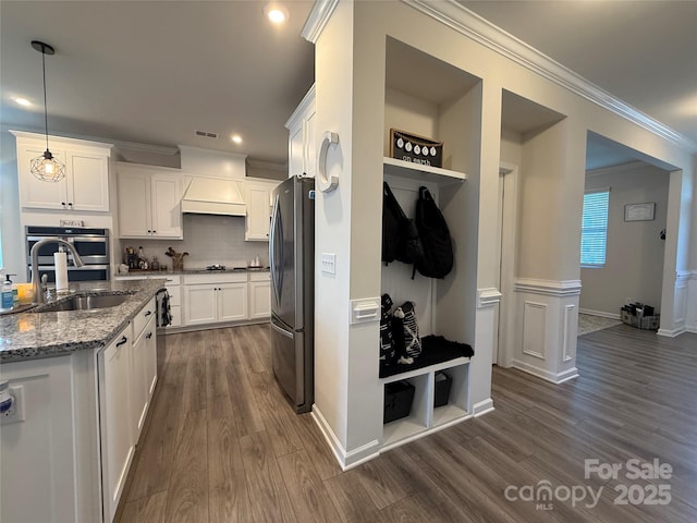 1016 Laggan Ln, Indian Trail, NC 28079 - kitchen featuring stainless steel appliances, a sink, dark wood-style flooring, white cabinets, and crown molding