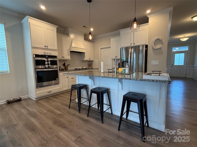 1016 Laggan Ln, Indian Trail, NC 28079 - kitchen with stainless steel appliances, ornamental molding, white cabinetry, tasteful backsplash, and a kitchen bar