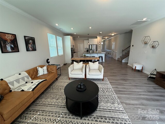 1016 Laggan Ln, Indian Trail, NC 28079 - living room featuring stairway, crown molding, wood finished floors, recessed lighting, and baseboards