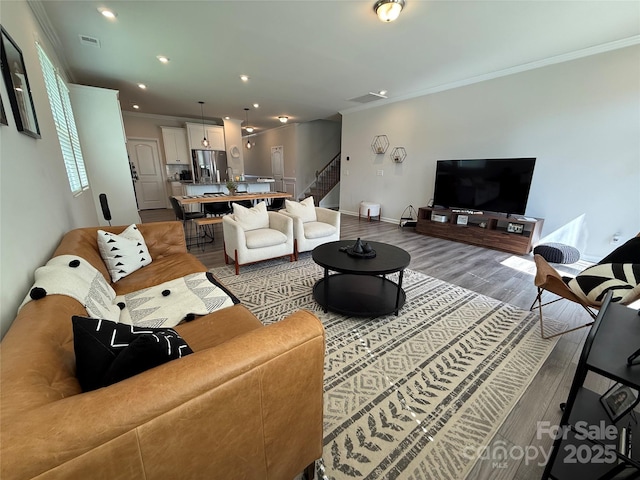 1016 Laggan Ln, Indian Trail, NC 28079 - living room featuring stairway, wood finished floors, ornamental molding, baseboards, and recessed lighting