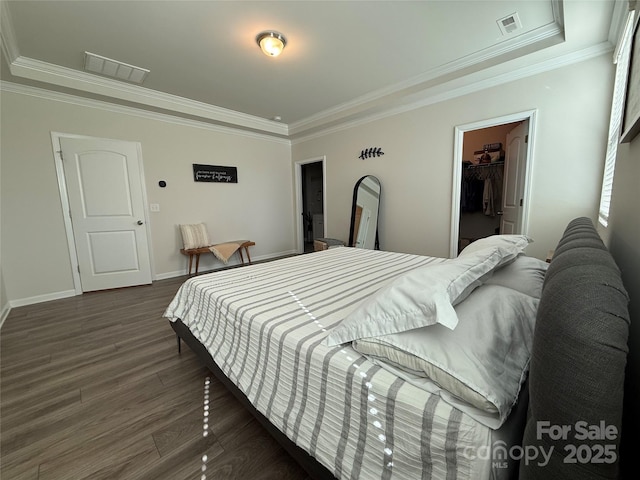 1016 Laggan Ln, Indian Trail, NC 28079 - bedroom featuring dark wood finished floors, crown molding, a walk in closet, baseboards, and a closet