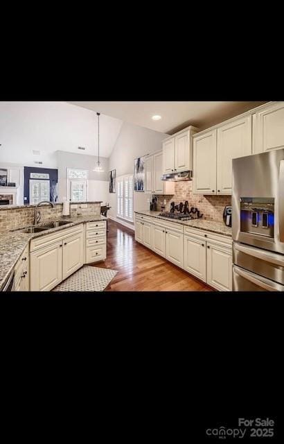2234 Donnington Ln NW, Concord, NC 28027 - kitchen with stainless steel appliances, lofted ceiling, backsplash, light wood-style floors, and a sink