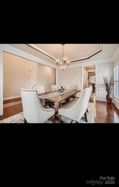 2234 Donnington Ln NW, Concord, NC 28027 - dining space featuring wood finished floors, a chandelier, a raised ceiling, and crown molding