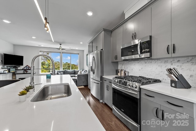 919 Cityscape Dr, Charlotte, NC 28205 - kitchen with stainless steel appliances, open floor plan, gray cabinetry, a sink, and recessed lighting