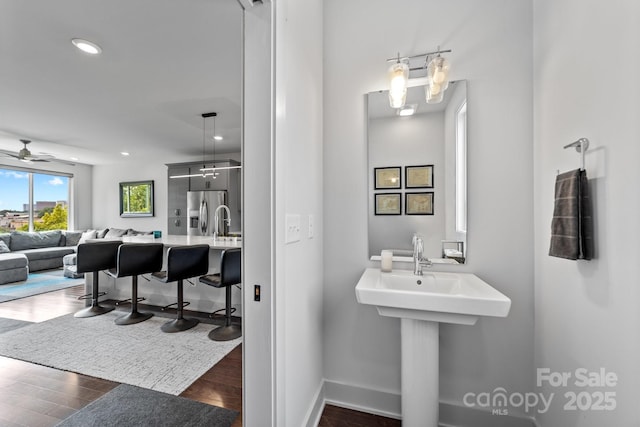 919 Cityscape Dr, Charlotte, NC 28205 - bathroom with a ceiling fan, wood finished floors, baseboards, a sink, and recessed lighting