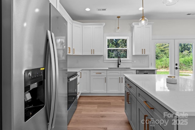 2220 Mooresville Rd, Salisbury, NC 28147 - kitchen with stainless steel refrigerator with ice dispenser, a sink, electric range oven, white cabinetry, and light wood-type flooring