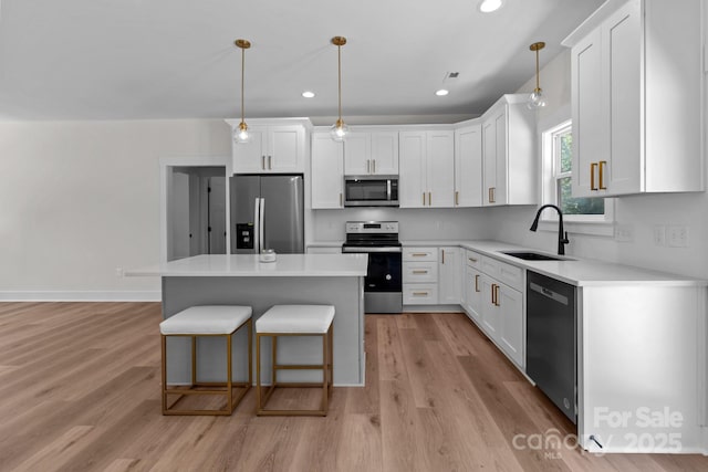 2220 Mooresville Rd, Salisbury, NC 28147 - kitchen with appliances with stainless steel finishes, a sink, white cabinets, a center island, and a kitchen bar