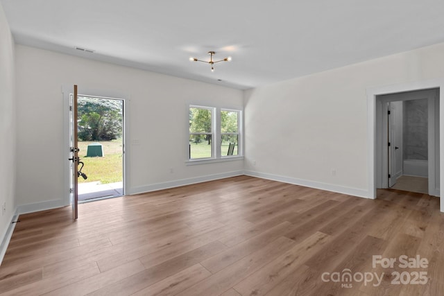 2220 Mooresville Rd, Salisbury, NC 28147 - unfurnished living room with light wood-style flooring, baseboards, and a chandelier