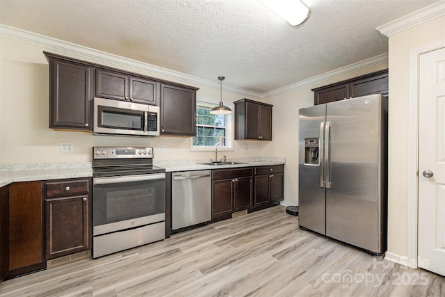 503 Apple St, Gibsonville, NC 27249 - kitchen with appliances with stainless steel finishes, dark brown cabinets, light wood-style floors, a sink, and crown molding