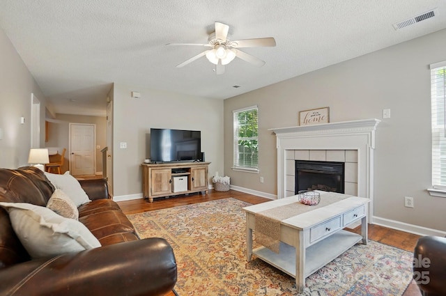 820 Settlement St, Clover, SC 29710 - living room featuring ceiling fan, dark wood-style flooring, a fireplace, a textured ceiling, and baseboards