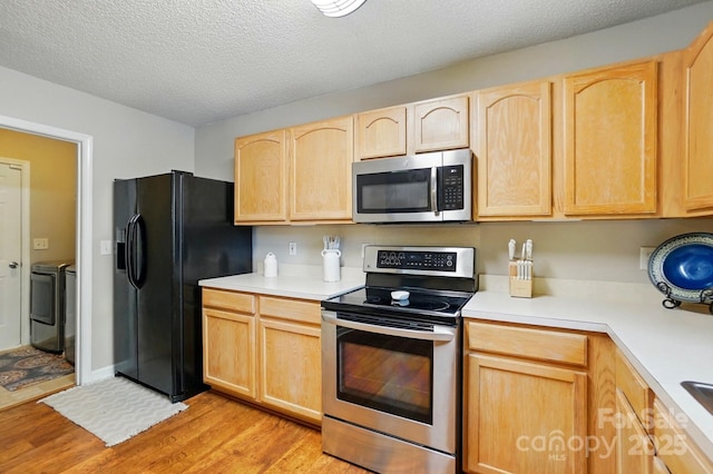 820 Settlement St, Clover, SC 29710 - kitchen with appliances with stainless steel finishes, light brown cabinetry, washer and dryer, light wood finished floors, and light countertops