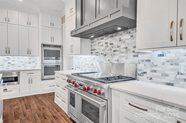 1622 Hunters Place Rd, York, SC 29745 - kitchen with appliances with stainless steel finishes, under cabinet range hood, tasteful backsplash, white cabinets, and light stone countertops