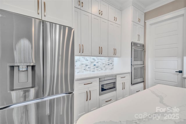 1622 Hunters Place Rd, York, SC 29745 - kitchen with appliances with stainless steel finishes, crown molding, decorative backsplash, white cabinetry, and light stone counters