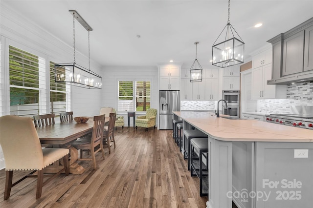 1622 Hunters Place Rd, York, SC 29745 - kitchen featuring a chandelier, stainless steel appliances, tasteful backsplash, dark wood-type flooring, and crown molding
