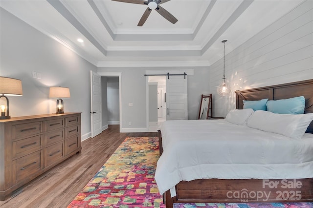 1622 Hunters Place Rd, York, SC 29745 - bedroom featuring a barn door, a raised ceiling, light wood-type flooring, and ornamental molding