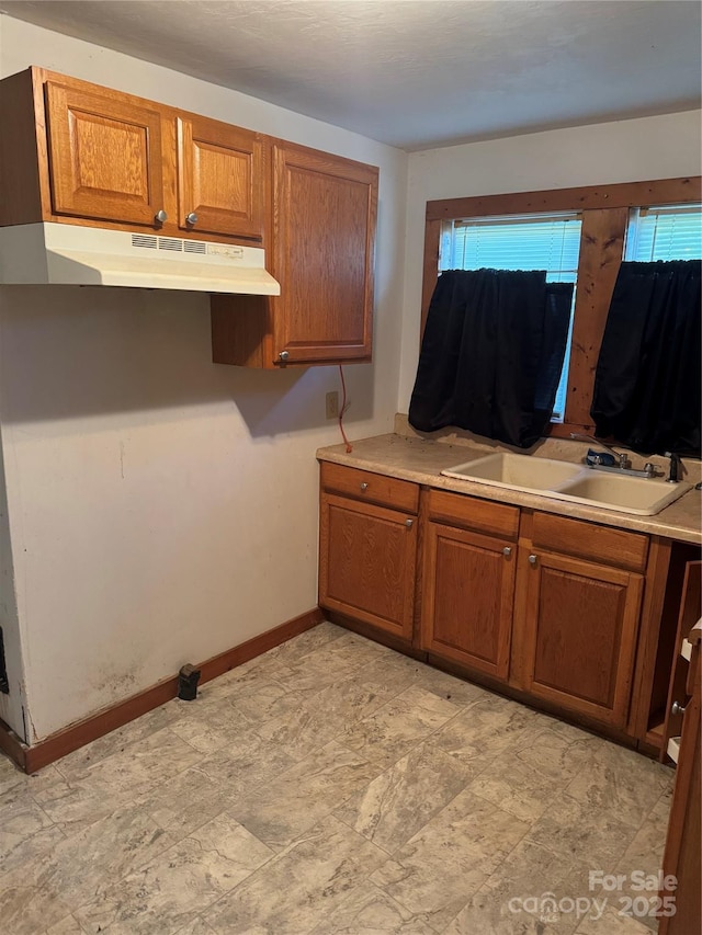241 Hamrick Dr, Ellenboro, NC 28040 - kitchen featuring a sink, under cabinet range hood, brown cabinets, and plenty of natural light