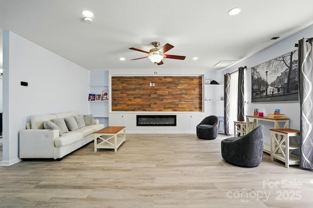 1005 Exodus Ct, Monroe, NC 28110 - living room featuring ceiling fan, recessed lighting, a glass covered fireplace, and wood finished floors