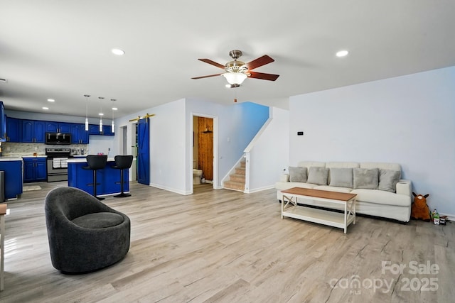 1005 Exodus Ct, Monroe, NC 28110 - living room featuring light wood finished floors, stairs, ceiling fan, recessed lighting, and baseboards