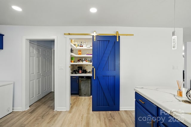1005 Exodus Ct, Monroe, NC 28110 - kitchen with blue cabinets, light wood finished floors, a barn door, and recessed lighting
