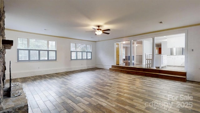 3151 Lynn Mountain Rd, Vale, NC 28168 - unfurnished living room with wood finished floors, ceiling fan, ornamental molding, a stone fireplace, and baseboards