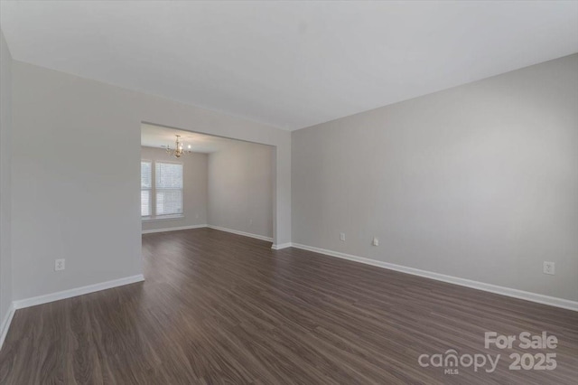 1111 Balcorn Pl, Charlotte, NC 28214 - unfurnished room featuring a chandelier, baseboards, and dark wood-style floors