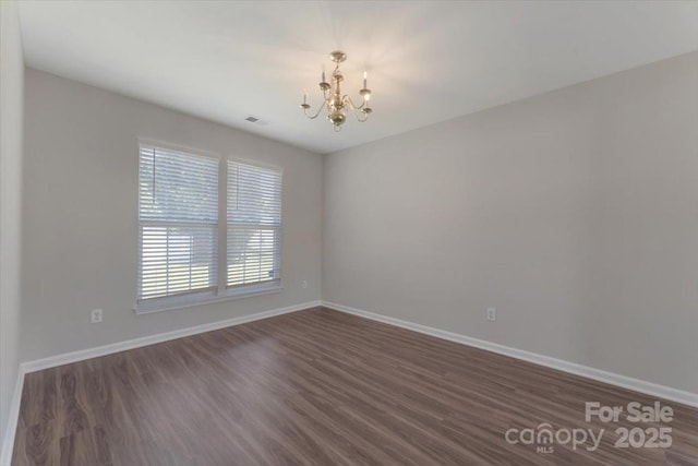 1111 Balcorn Pl, Charlotte, NC 28214 - unfurnished room with a chandelier, dark wood finished floors, and baseboards