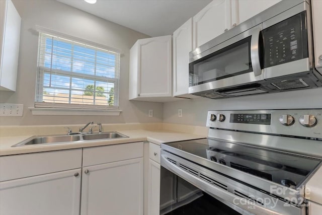 1111 Balcorn Pl, Charlotte, NC 28214 - kitchen with appliances with stainless steel finishes, a sink, white cabinetry, and light countertops