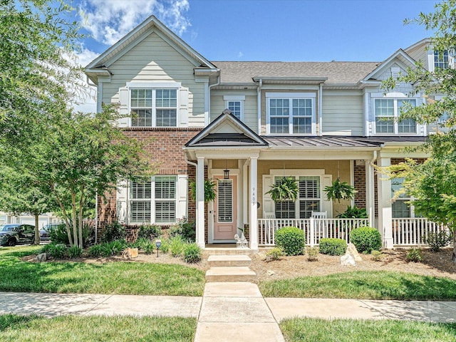 9405 Gladden Hill Ln, Pineville, NC 28134 - townhome / multi-family property featuring brick siding, covered porch, and roof with shingles