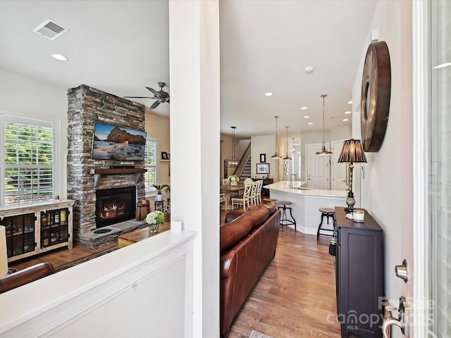 9405 Gladden Hill Ln, Pineville, NC 28134 - living room featuring ceiling fan, stairway, light wood finished floors, a fireplace, and recessed lighting