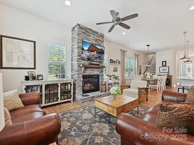 9405 Gladden Hill Ln, Pineville, NC 28134 - living area featuring wood finished floors, ceiling fan, a stone fireplace, stairway, and recessed lighting