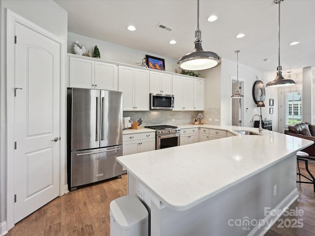 9405 Gladden Hill Ln, Pineville, NC 28134 - kitchen featuring appliances with stainless steel finishes, wood finished floors, a sink, backsplash, and recessed lighting