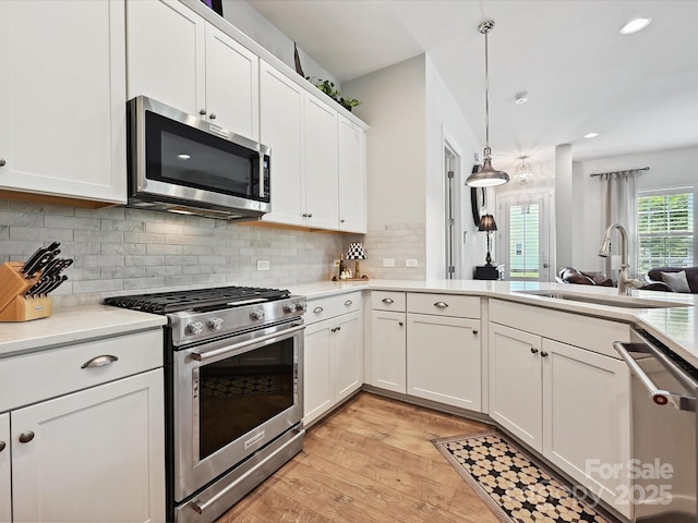 9405 Gladden Hill Ln, Pineville, NC 28134 - kitchen with appliances with stainless steel finishes, a sink, light countertops, white cabinets, and light wood-type flooring
